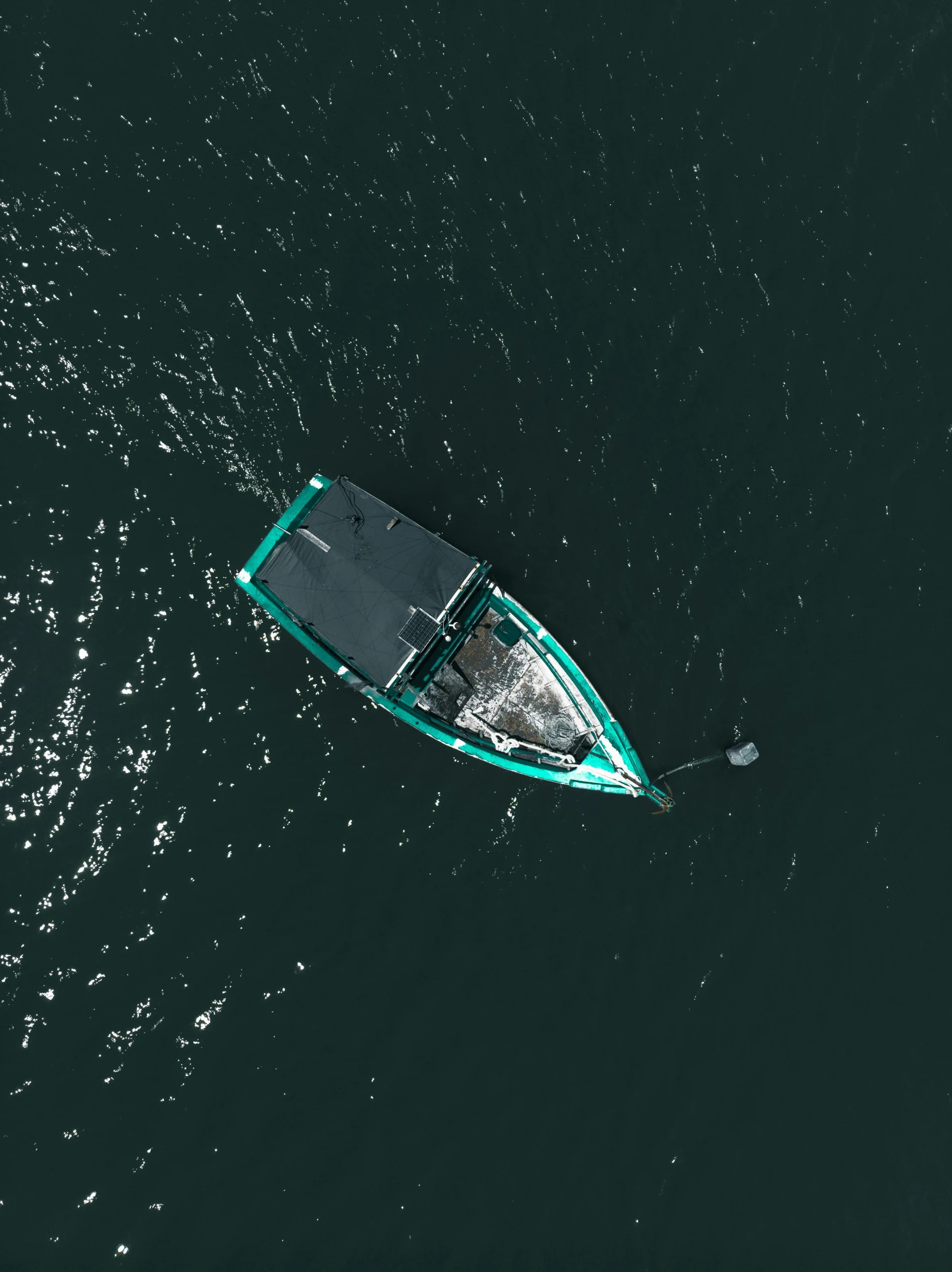 a small boat on a body of water with a green boat