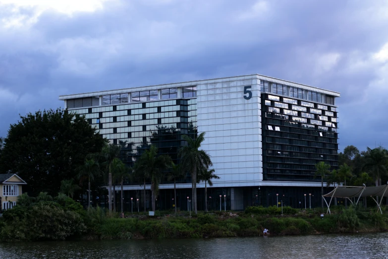 a large white and black building in front of a body of water