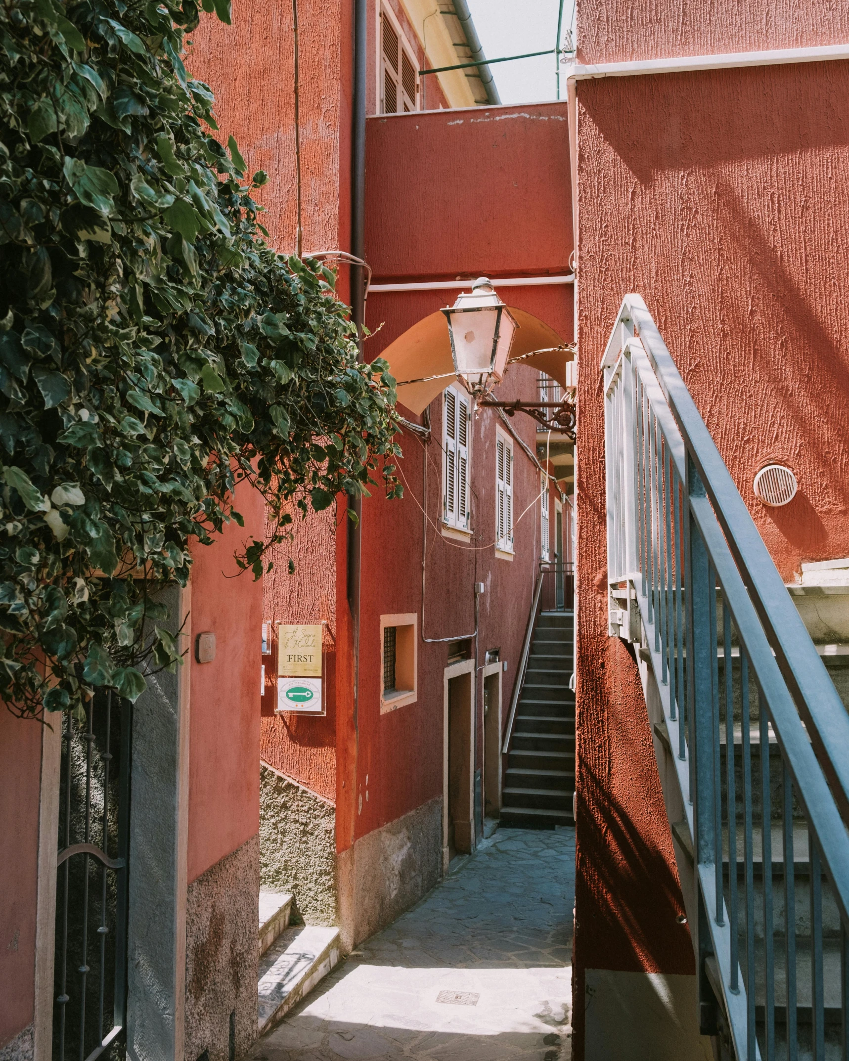 this alley way has a staircase and red wall