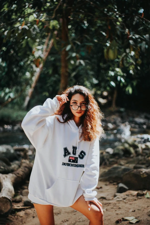 a woman in glasses with a white sweatshirt on