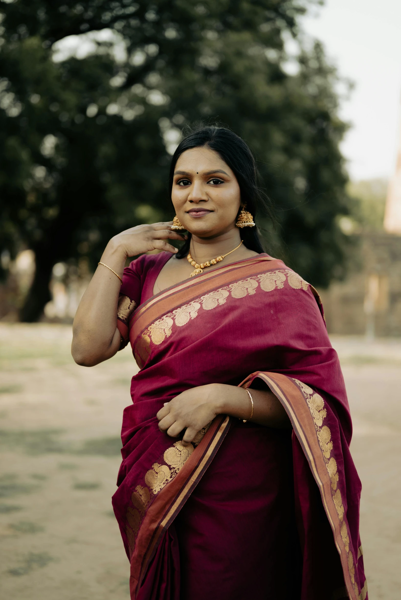 a woman with dark hair wearing a maroon sari