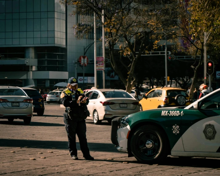 a cop talking to another cop near some parked cars