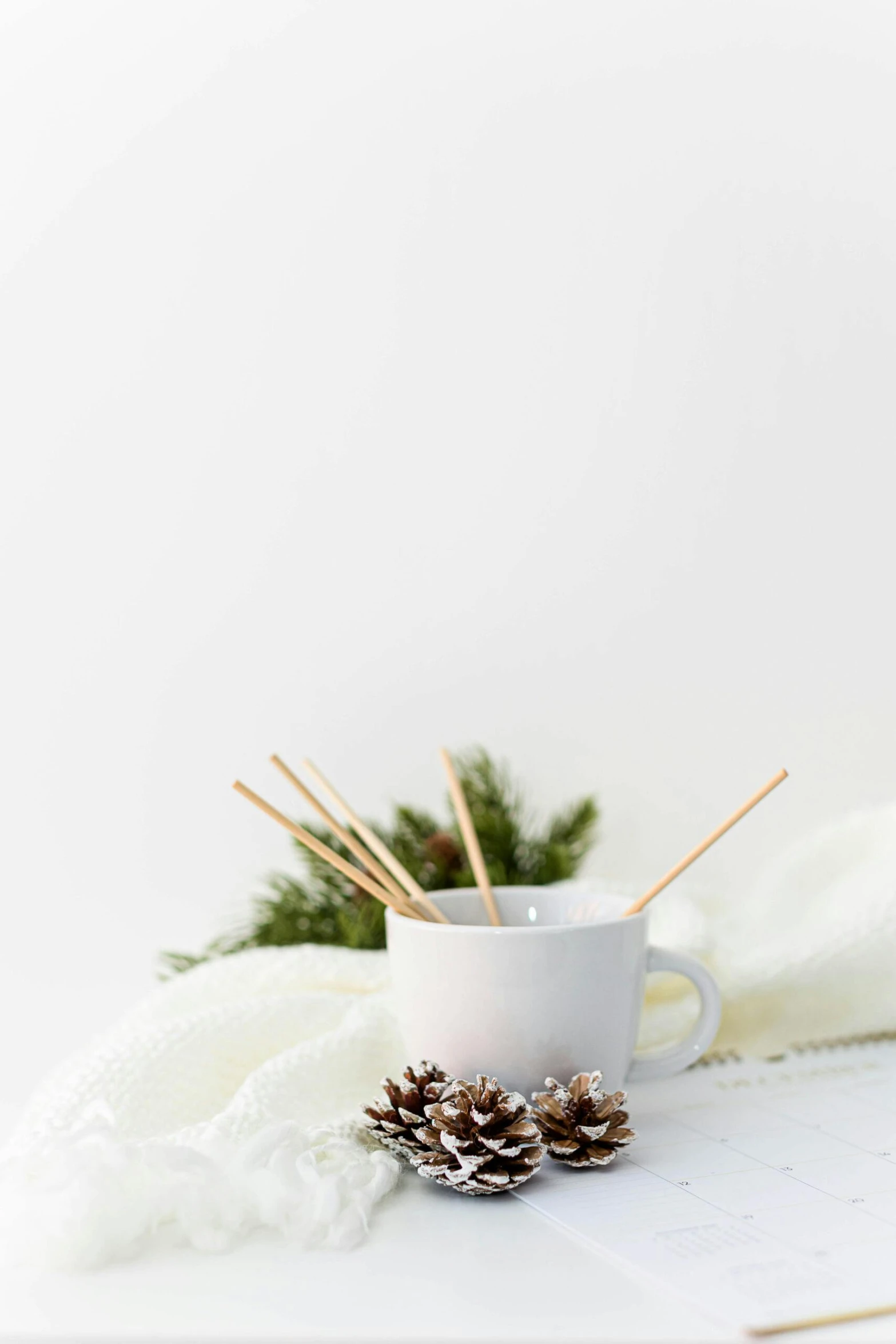 a cup of coffee with christmas decorations and needles