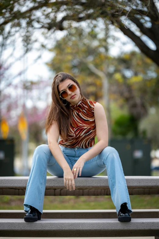 a girl sitting on the ground with her head resting on the bench