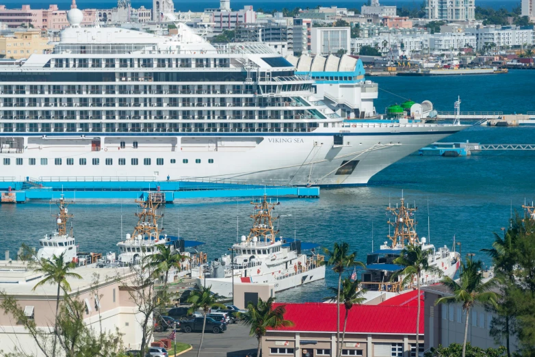 a white cruise ship in the water next to other boats