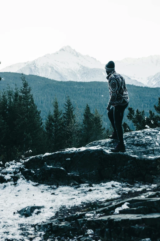 a man standing on top of a large rock