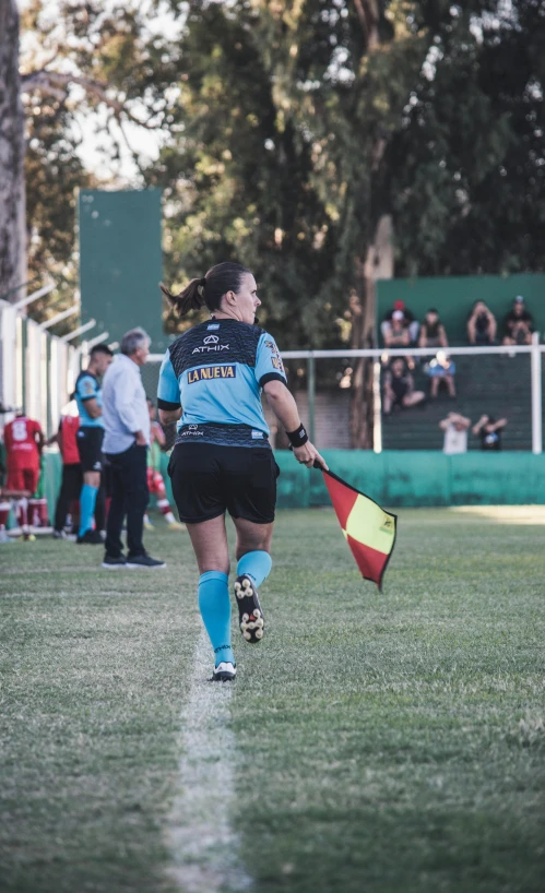 a girl in soccer uniform holding a yellow and red frisbee