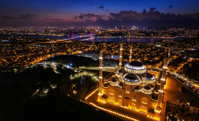 the city lights at night are bright behind a large building