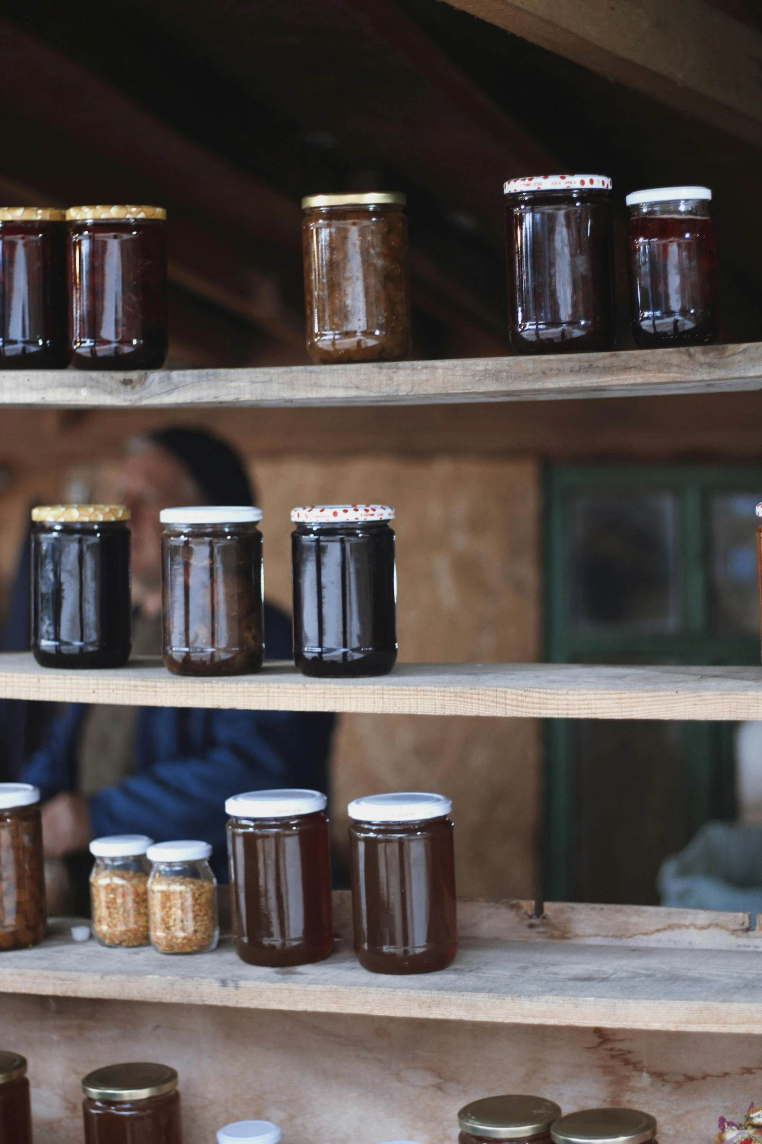 a man stands behind the jars on the shelf