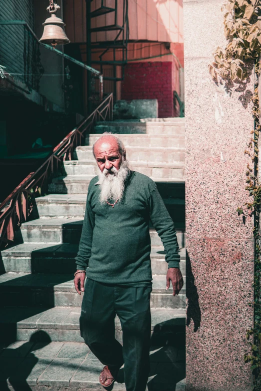 a man with long white beard standing on stairs