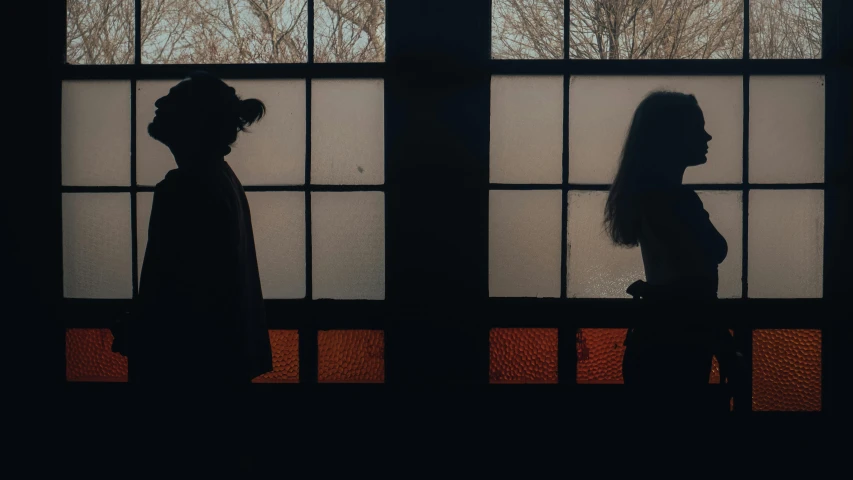 silhouettes of people against a window in the morning