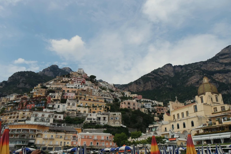 many buildings on a mountain are shown behind umbrellas