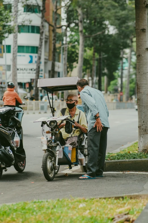 two people standing next to two small motorcycles