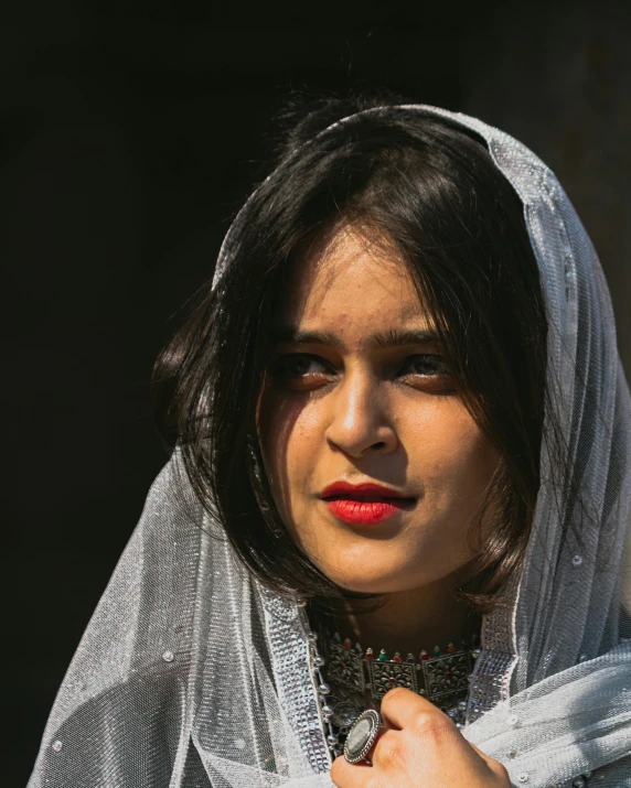 a woman wearing veil and wearing ring on finger