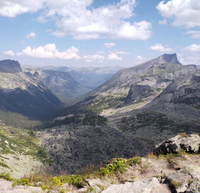 a man standing on top of a rock overlooking mountains