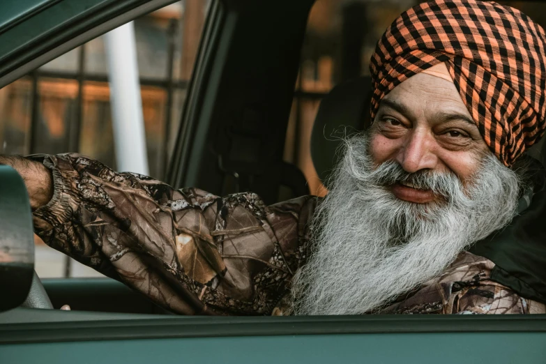 the man is sitting in the car posing for a picture