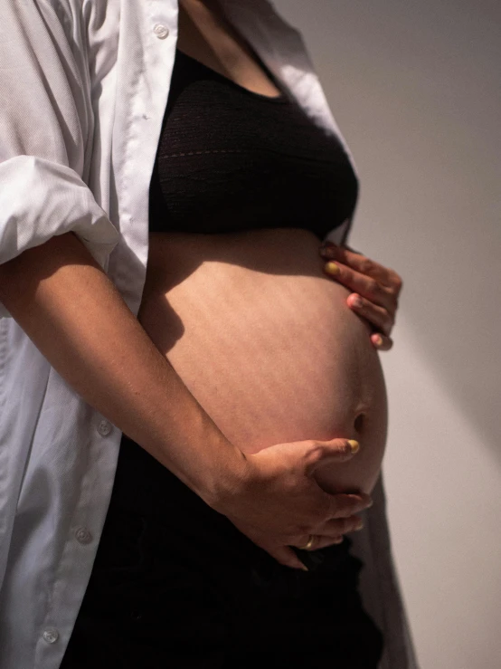 a pregnant woman in a black dress shirt