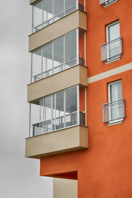 a tall orange building has balconies and a balcony