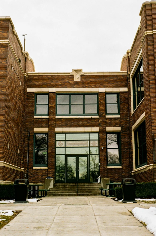 a large brown brick building with several benches on the walkway