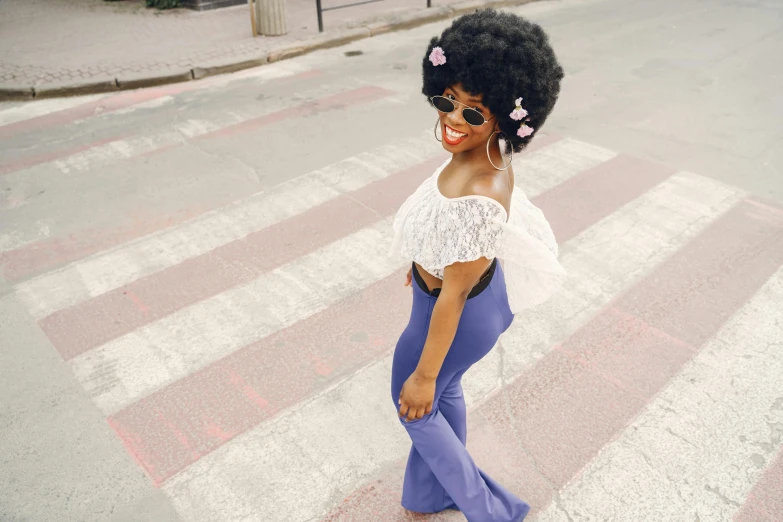 a woman with afro hair standing in the street