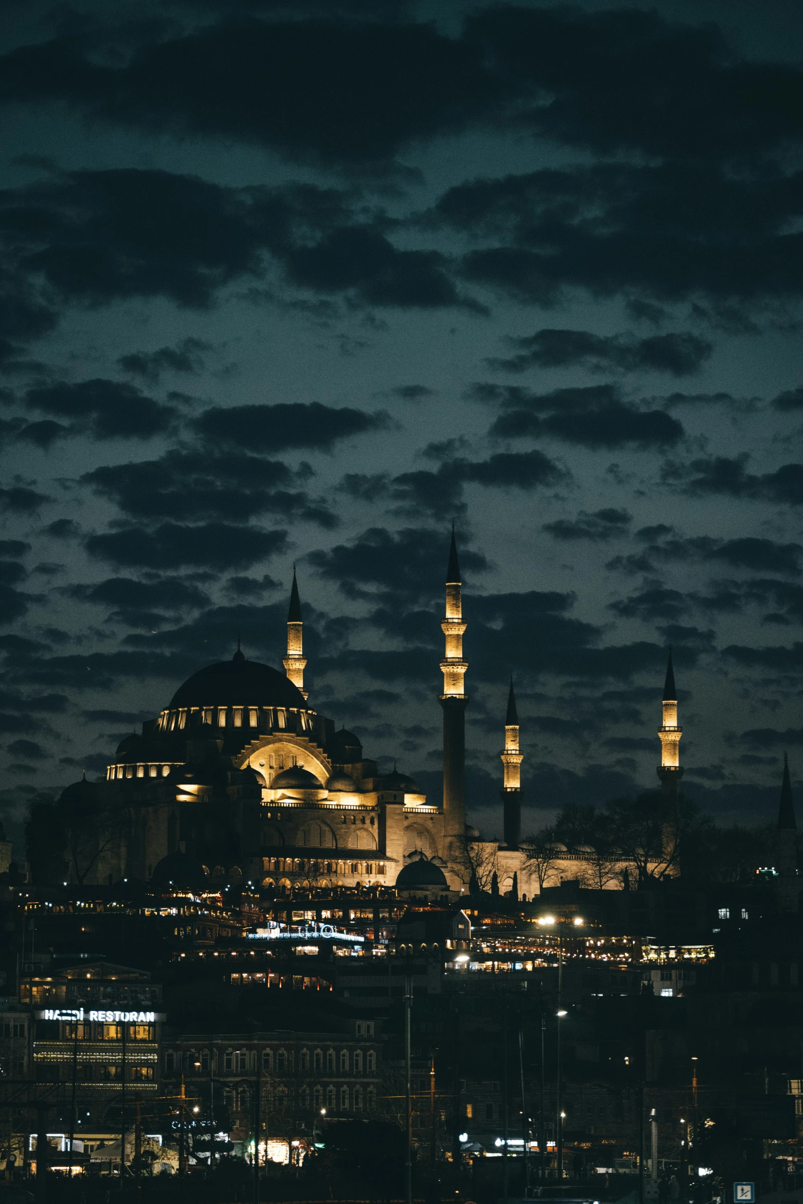 a large building with domes lit up in the night sky