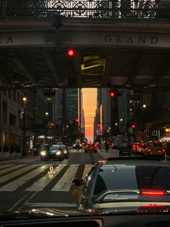 cars drive down a busy street at night