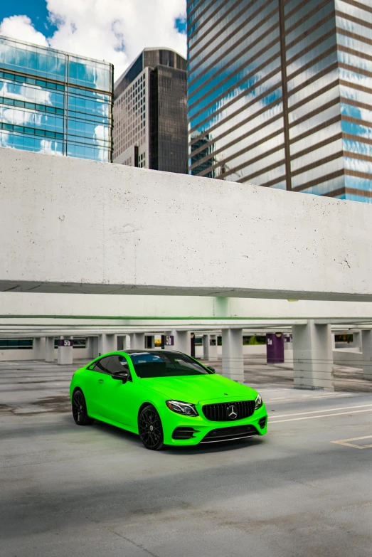 a green sports car driving down a street