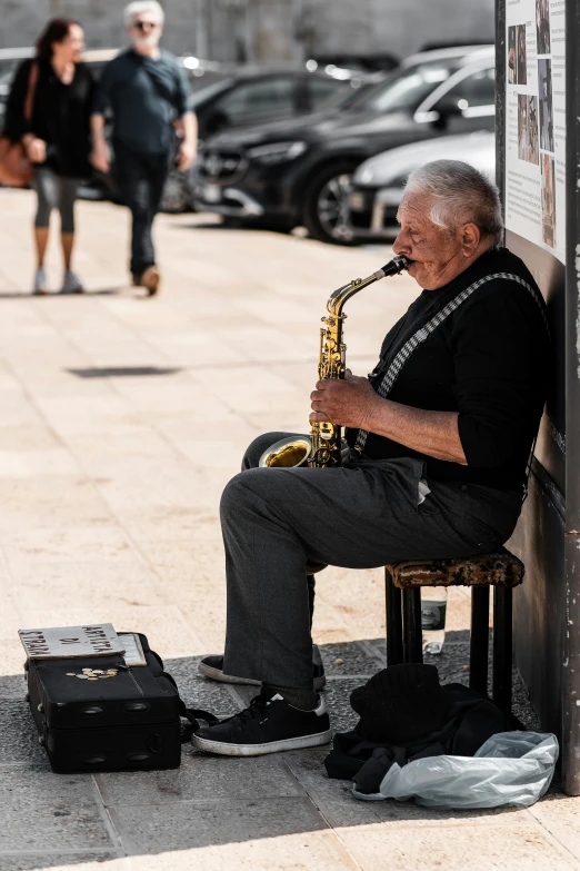 a man is sitting and playing saxophone