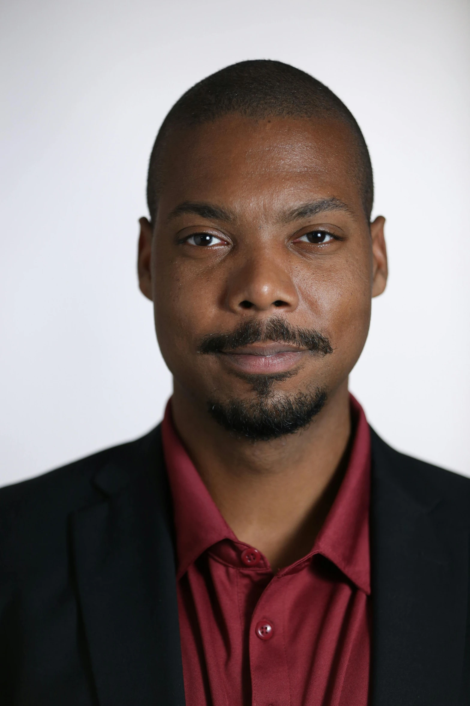 a man wearing a red shirt and black jacket