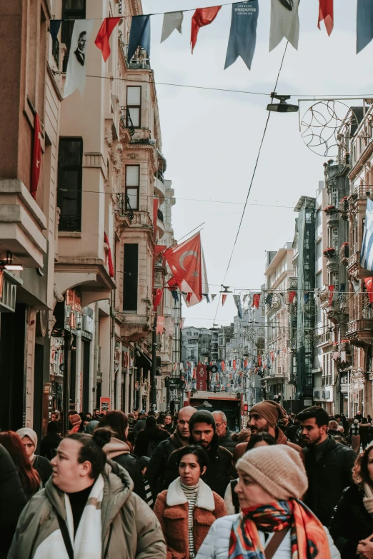 large crowd standing in a city center and walking around