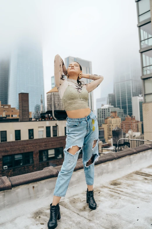 a woman in high rise jeans is standing on a roof