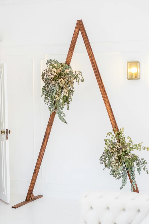 a pair of triangle shaped wooden racks displaying potted plants