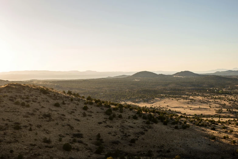 mountains and desert land at sunset with sun flares over the horizon