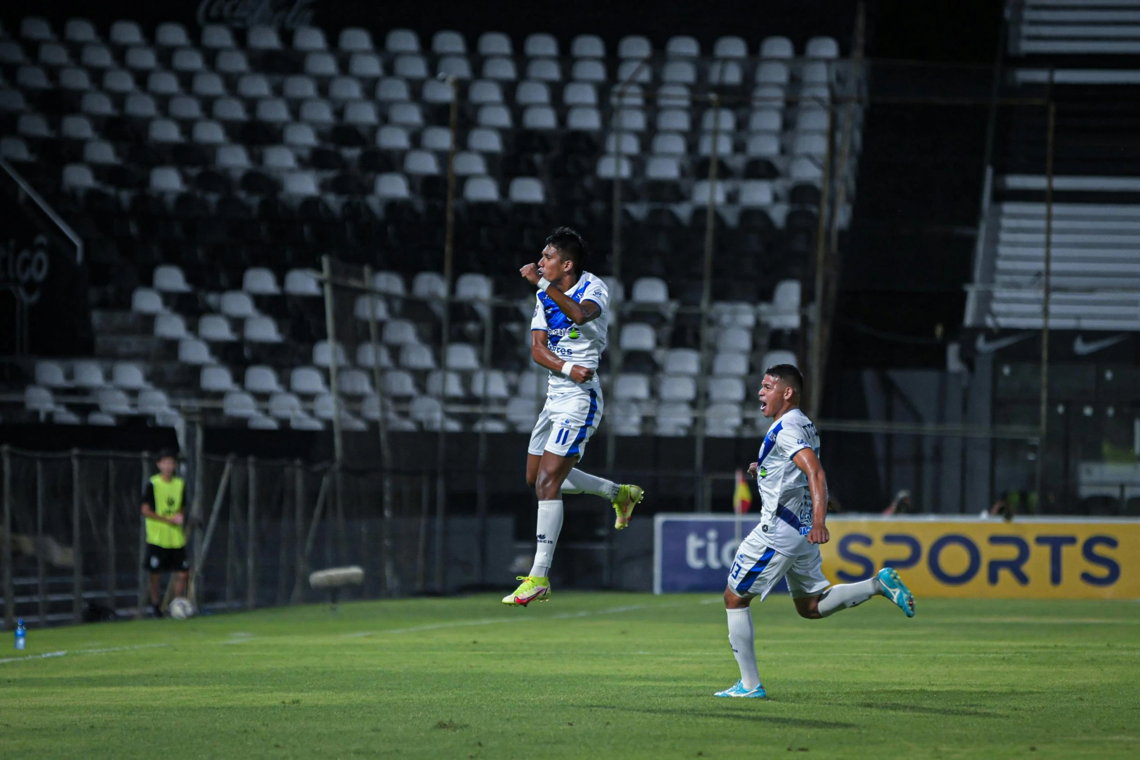 a soccer player is jumping up high to catch the ball