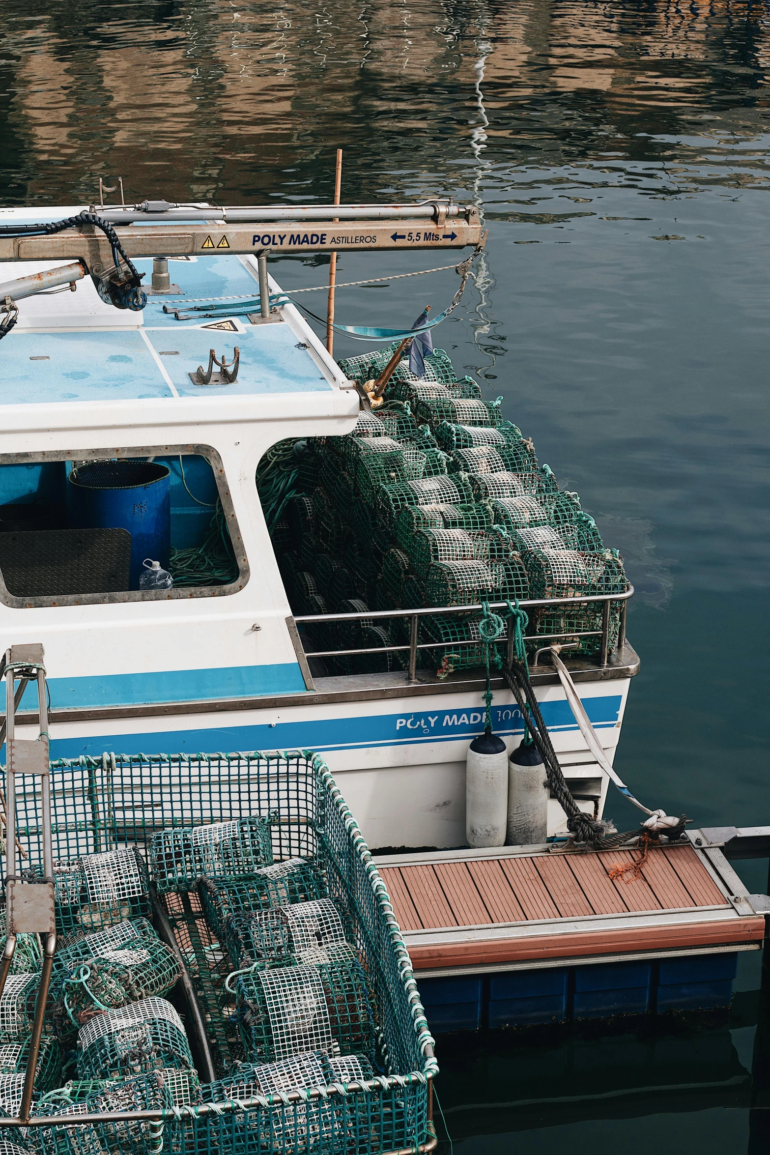 a boat with green wire around it docked in water