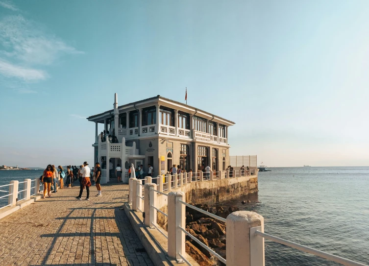 people on a dock watching a boat pass by