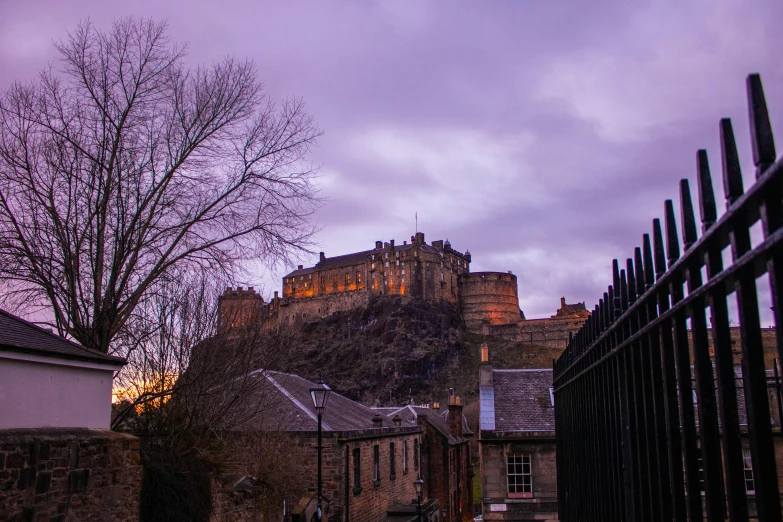 the edinburgh castle at night is illuminated by the moon