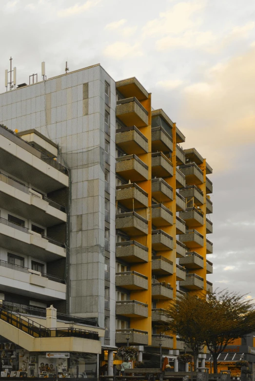 a grey building with yellow balconies and a clock tower