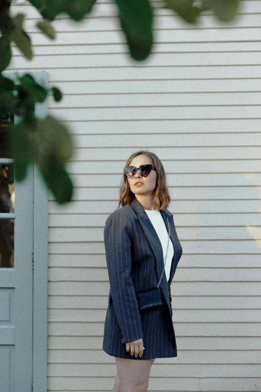 the model is standing in front of a house