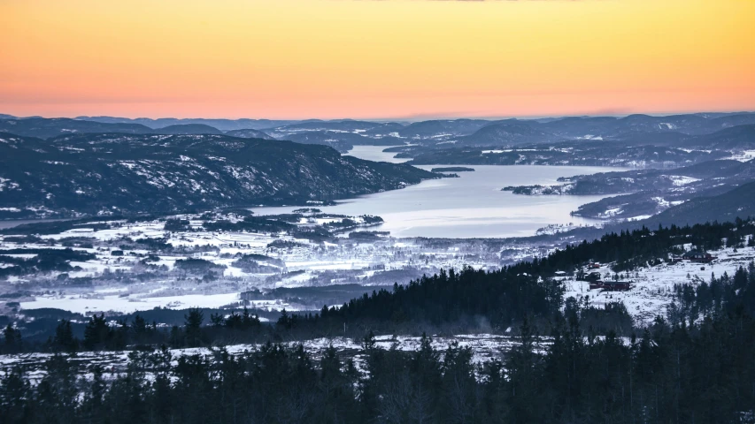 a view of trees and snow from the top of a mountain