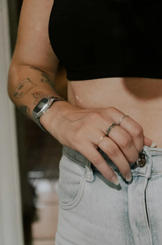 a person in black shirt with rings on their fingers