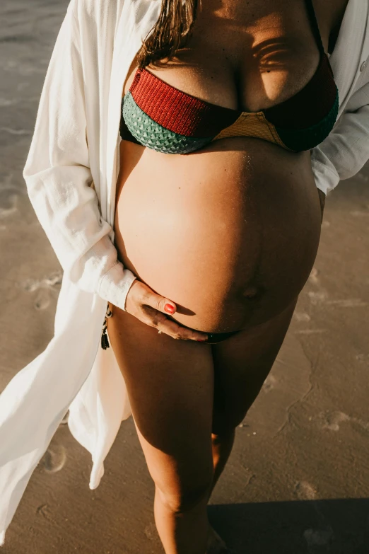 a woman in a bikini on the beach posing for a po