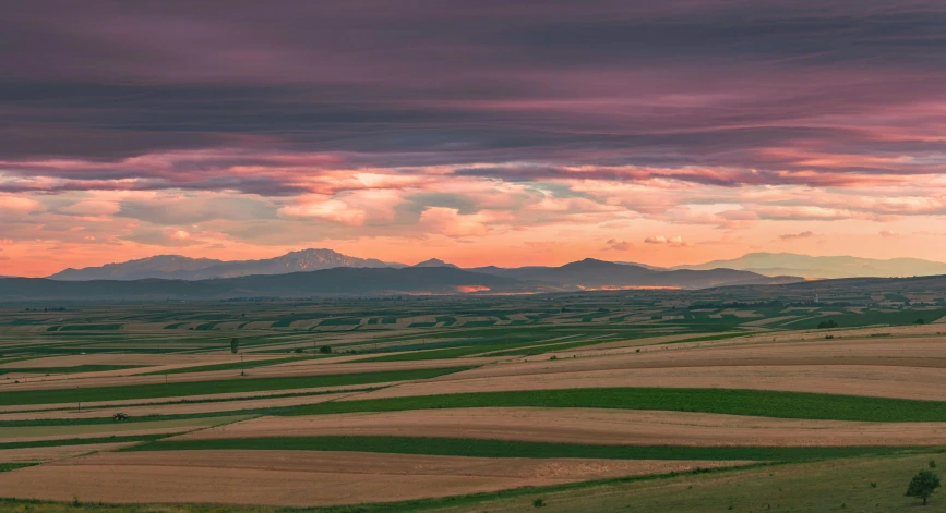 the view from a plane of rolling hills, hills and plains in a sunset