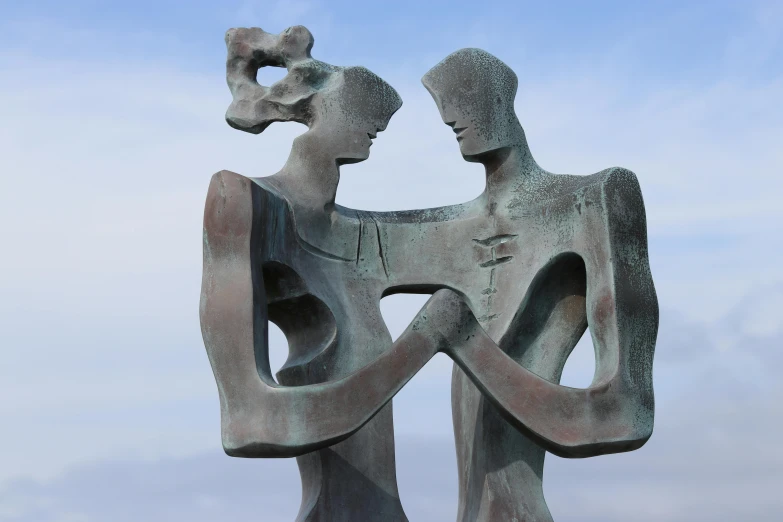 the sculpture shows two people emcing and one is standing behind it