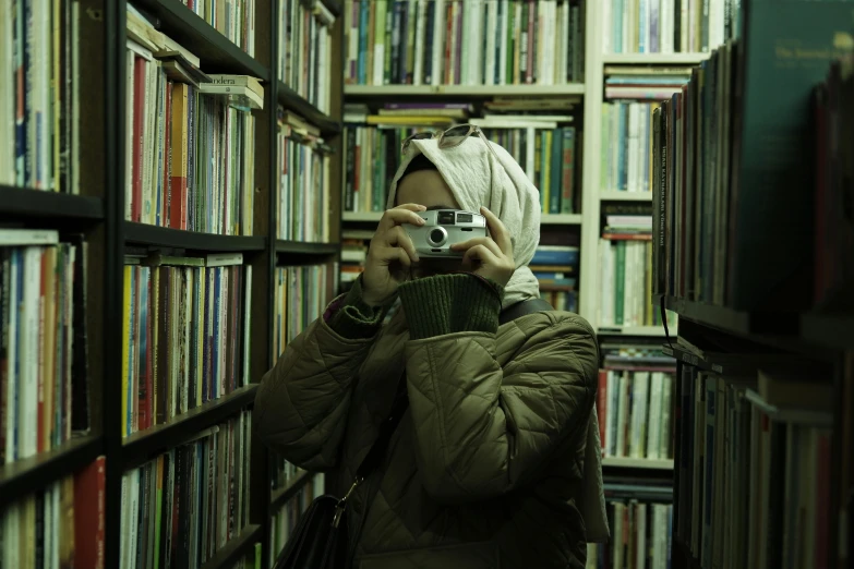 a person is standing in a book store taking pictures of books