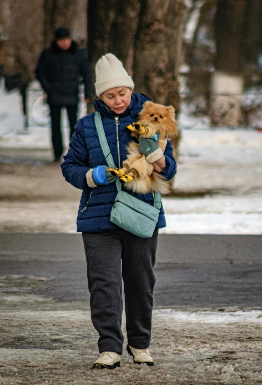 a woman is holding her dog and looking down