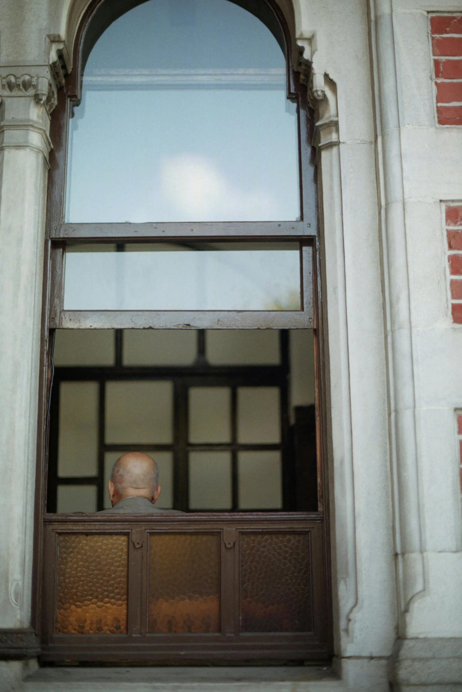 the older man is looking through the window at the sky