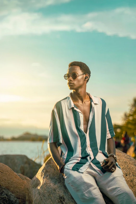 a man wearing sunglasses sitting on a rock