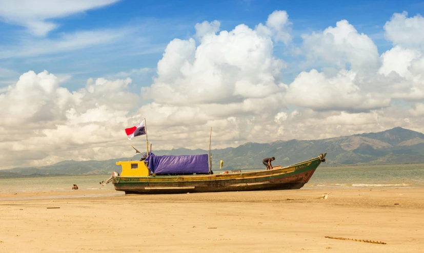 a boat with a blue cover parked at the beach