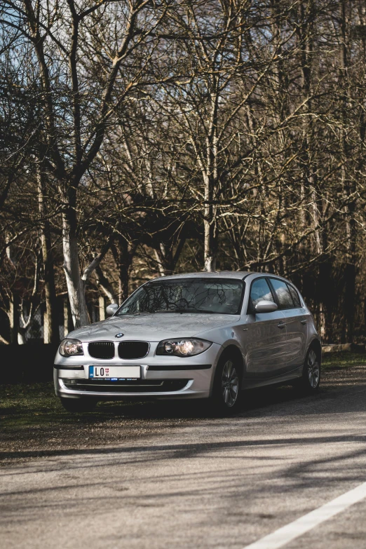 a silver car parked next to the side of the road